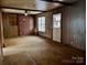 Cozy living room with paneled walls, a brick fireplace and carpeted floors at 6862 Royal Heights Cir, Hickory, NC 28602