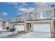 Two story townhome with gray siding, stone accents, and a two-car garage at 8119 Merryvale Ln, Charlotte, NC 28214