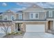 Two-story townhome with gray siding, stone accents, and a two-car garage at 8119 Merryvale Ln, Charlotte, NC 28214