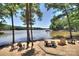 Relaxing lakefront view with chairs lakeside and a dock in the distance at 8119 Merryvale Ln, Charlotte, NC 28214