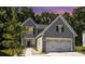 Two-story gray house with white garage doors at dusk at 1163 Ryan Meadow Dr, Monroe, NC 28110