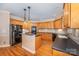 Kitchen with island, wood cabinets, and black appliances at 11805 Prestmoor Ct, Charlotte, NC 28262