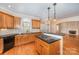 Kitchen with island, wood cabinets, and black appliances at 11805 Prestmoor Ct, Charlotte, NC 28262