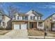 Two-story house with a brick and siding exterior, two-car garage, and a front porch at 141 Silverspring Pl, Mooresville, NC 28117