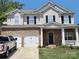 Charming two-story home with a brick facade, white trim, black shutters, and a two-car garage at 141 Silverspring Pl, Mooresville, NC 28117