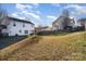 View of backyard with sloped yard and neighboring homes at 14311 Riding Hill Ave, Charlotte, NC 28213