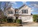 Two-story house with white siding, attached garage, and landscaping at 14311 Riding Hill Ave, Charlotte, NC 28213