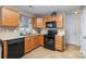 Kitchen with wooden cabinets, black appliances, and a pantry at 14311 Riding Hill Ave, Charlotte, NC 28213