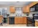 Kitchen features wooden cabinets, black appliances, and a double sink at 14311 Riding Hill Ave, Charlotte, NC 28213