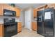 Kitchen boasts black appliances and ample wood cabinetry at 14311 Riding Hill Ave, Charlotte, NC 28213