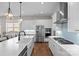 Bright kitchen boasts white cabinets, an expansive island, stainless steel appliances, and decorative pendant lighting at 14531 Crosswater Ln, Charlotte, NC 28278