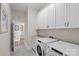 Well-lit laundry room with modern appliances, granite countertops, and ample storage cabinets at 14531 Crosswater Ln, Charlotte, NC 28278