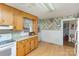 Retro kitchen features wood cabinets, vintage wallpaper, and a view into adjacent room at 1979 Charlotte Hwy, Mooresville, NC 28115