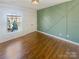 Bedroom with green geometric accent wall and hardwood floors at 2219 Lochview St, Pineville, NC 28134