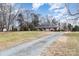 House with gravel driveway and large yard, offering privacy and space at 3219 Monte Dr, Monroe, NC 28110