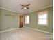 A carpeted bedroom featuring neutral colors, ceiling fan, and two windows providing natural light at 3303 Reid Cir, Monroe, NC 28112