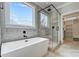 Modern bathroom with a soaking tub, glass shower, and neutral tile at 3428 Greene Rd, Monroe, NC 28110