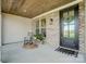 Inviting covered porch with brick accents, a rocking chair, and a welcoming entrance at 3428 Greene Rd, Monroe, NC 28110