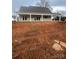 Rear view of house showcasing a large covered patio and unfinished yard at 3428 Greene Rd, Monroe, NC 28110