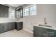 Well-lit laundry room featuring custom cabinets, quartz countertops, and modern sink fixture at 3428 Greene Rd, Monroe, NC 28110