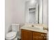 Clean and functional bathroom with a wood vanity and updated toilet at 3821 Bullard St, Charlotte, NC 28208