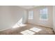 Bright bedroom with neutral walls, carpet, and two large windows at 3821 Bullard St, Charlotte, NC 28208