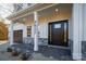 Inviting front porch with stone flooring, a black front door, and white columns at 4827 Brookridge Ne Dr, Hickory, NC 28601