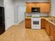 Kitchen boasts wood cabinets, tile floor and stainless steel appliances at 5573 Prosperity View Dr, Charlotte, NC 28269