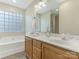 Well-lit bathroom boasting a double sink vanity, a large mirror, and a jetted tub for ultimate relaxation at 5904 Bryant Ln, Waxhaw, NC 28173