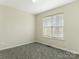 Bright bedroom featuring neutral walls, plush carpeting, and a window providing ample natural light at 5904 Bryant Ln, Waxhaw, NC 28173