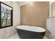 Modern bathroom features a freestanding tub with stylish fixtures and a window view of trees at 6133 Berryhill Towns Dr, Charlotte, NC 28270