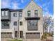 Stylish townhome with a painted brick facade, complemented by modern dark-trim windows and attached garage at 6133 Berryhill Towns Dr, Charlotte, NC 28270