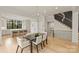 This dining room is open to the kitchen, and features hardwood floors and a staircase with black metal railings at 6133 Berryhill Towns Dr, Charlotte, NC 28270