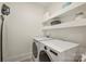 Bright laundry room with modern washer and dryer, and open shelving for storage at 6133 Berryhill Towns Dr, Charlotte, NC 28270