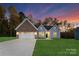 Brick and gray exterior of a single-story house with a two-car garage and landscaped lawn at 681 Journey Sw St, Concord, NC 28025