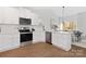 White kitchen with stainless steel appliances and an island that overlooks the living room at 681 Journey Sw St, Concord, NC 28025