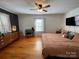 Cozy bedroom with wood floors, a ceiling fan, and a charming accent wall with a flat-screen TV at 7860 Georgia Ave, Kannapolis, NC 28081