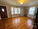 Bright living room with gleaming hardwood floors, neutral walls, and natural light streaming through large windows at 7860 Georgia Ave, Kannapolis, NC 28081