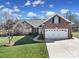 Charming brick home featuring an attached two-car garage, well-maintained lawn, and mature landscaping at 849 Treva Anne Sw Dr, Concord, NC 28027