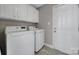 Well-lit laundry room features a washer, dryer, and ample cabinet storage at 849 Treva Anne Sw Dr, Concord, NC 28027