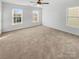 Large bedroom with neutral carpeting and multiple windows at 8835 Merrie Rose Ave, Charlotte, NC 28213