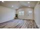 Bright living room with vaulted ceiling, large window, and wood-look flooring at 100 Howell St # 13A, Hickory, NC 28601