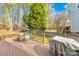 Outdoor wooden deck featuring a dining table, seating, and a grill at 10105 Bon Meade Ln, Cornelius, NC 28031