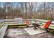 Outdoor deck featuring a table with two orange chairs and bench seating for enjoying the surrounding wooded view at 1025 Twin Lakes Rd, Rock Hill, SC 29732