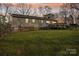 Back exterior view featuring a wooden deck and brick foundation, surrounded by a lush green lawn at 1025 Twin Lakes Rd, Rock Hill, SC 29732