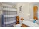 Cozy bathroom featuring a framed artwork above the toilet and a shower with a gray and white striped curtain at 1025 Twin Lakes Rd, Rock Hill, SC 29732