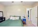 Bedroom with green bedding, carpet, ceiling fan, blue side table, and partially opened white door at 1025 Twin Lakes Rd, Rock Hill, SC 29732