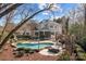 Backyard oasis featuring a sparkling pool, stone fireplace, outdoor seating, and professionally landscaped grounds at 110 Lynbrook Dr, Davidson, NC 28036