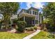 Charming backyard featuring a screened porch, brick patio, and stone pathway through the lush landscaping at 110 Lynbrook Dr, Davidson, NC 28036