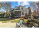 A backyard featuring a screened porch and stone patio that is surrounded by landscaping and mature trees at 110 Lynbrook Dr, Davidson, NC 28036